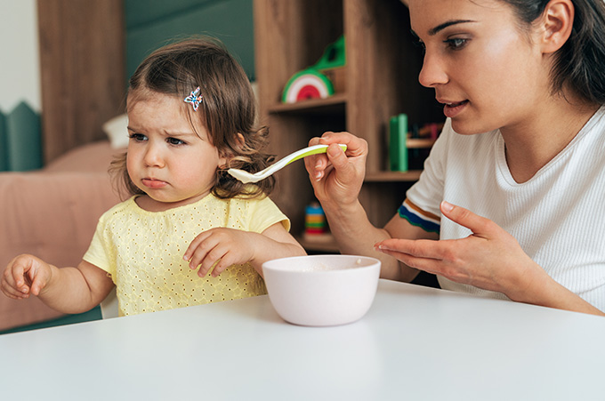 Mam intentando darle comida a nia que no quiere comer